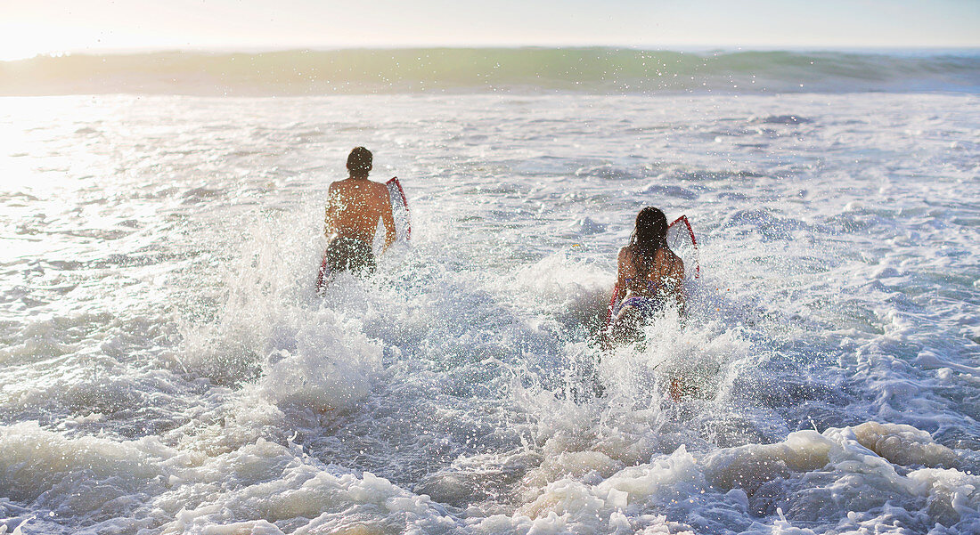 Couple surfing in ocean