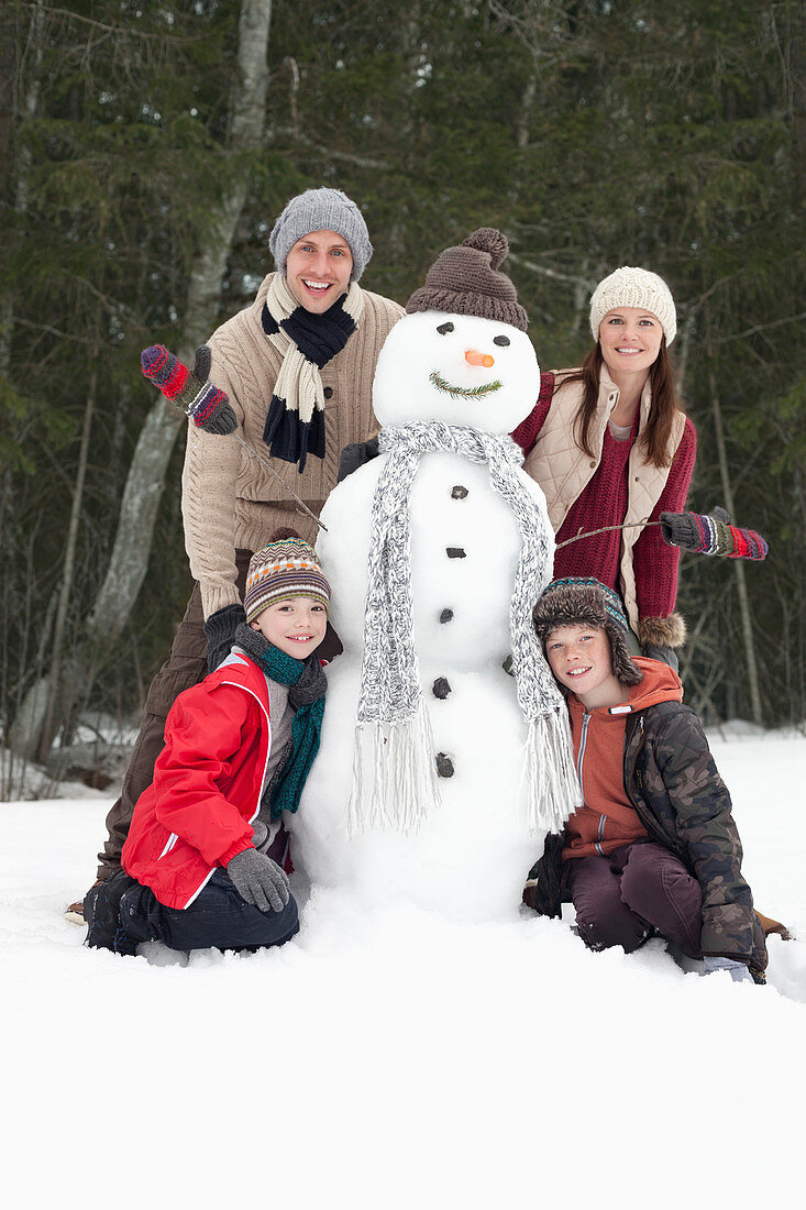 Portrait of happy family with snowman