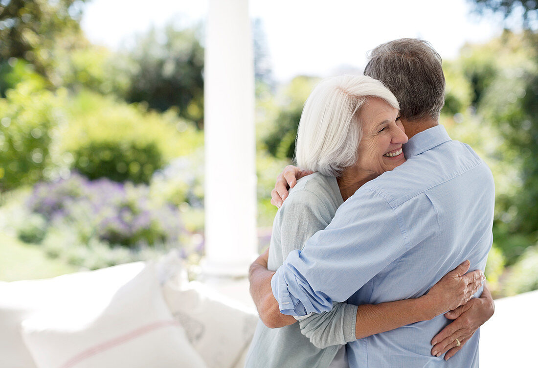 Senior couple hugging on patio