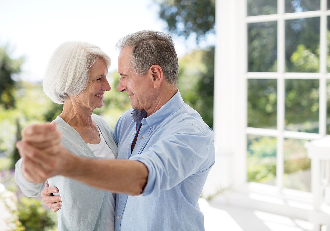 Senior couple dancing on patio