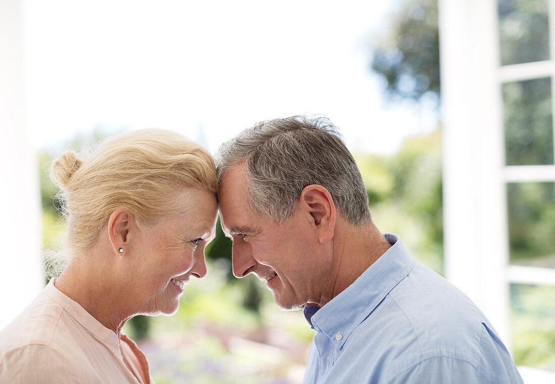 Senior couple leaning head to head