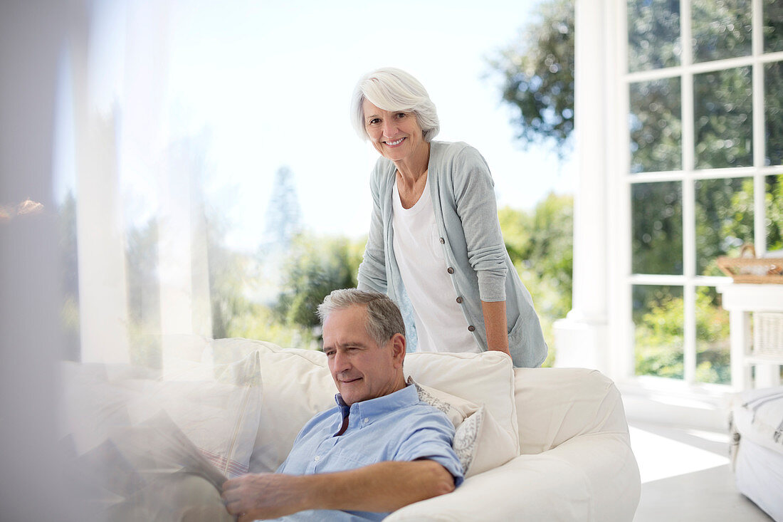 Senior couple relaxing on patio sofa