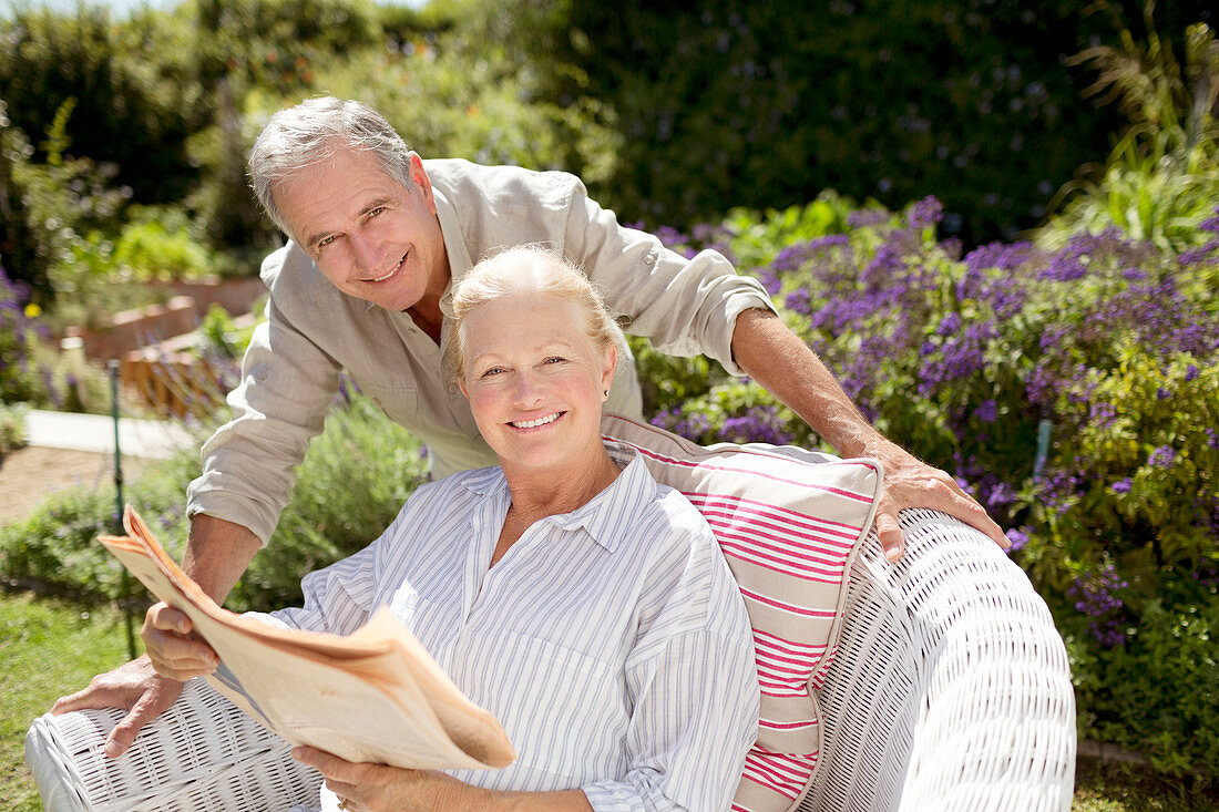 Senior couple reading newspaper in garden