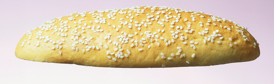 Top half of a hamburger roll with sesame seeds