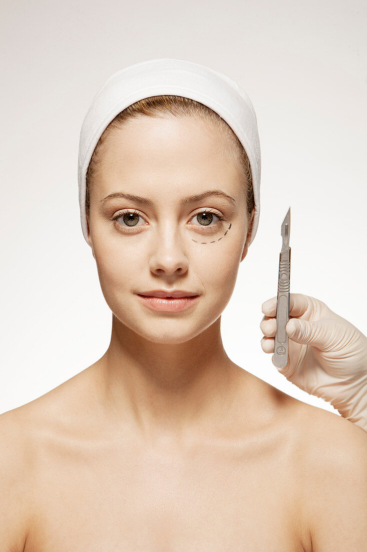 Plastic surgeon marking woman's face