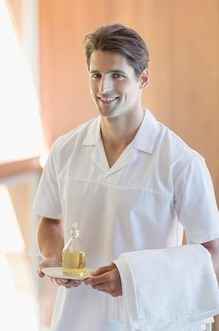 Masseuse carrying pitcher of oil at spa