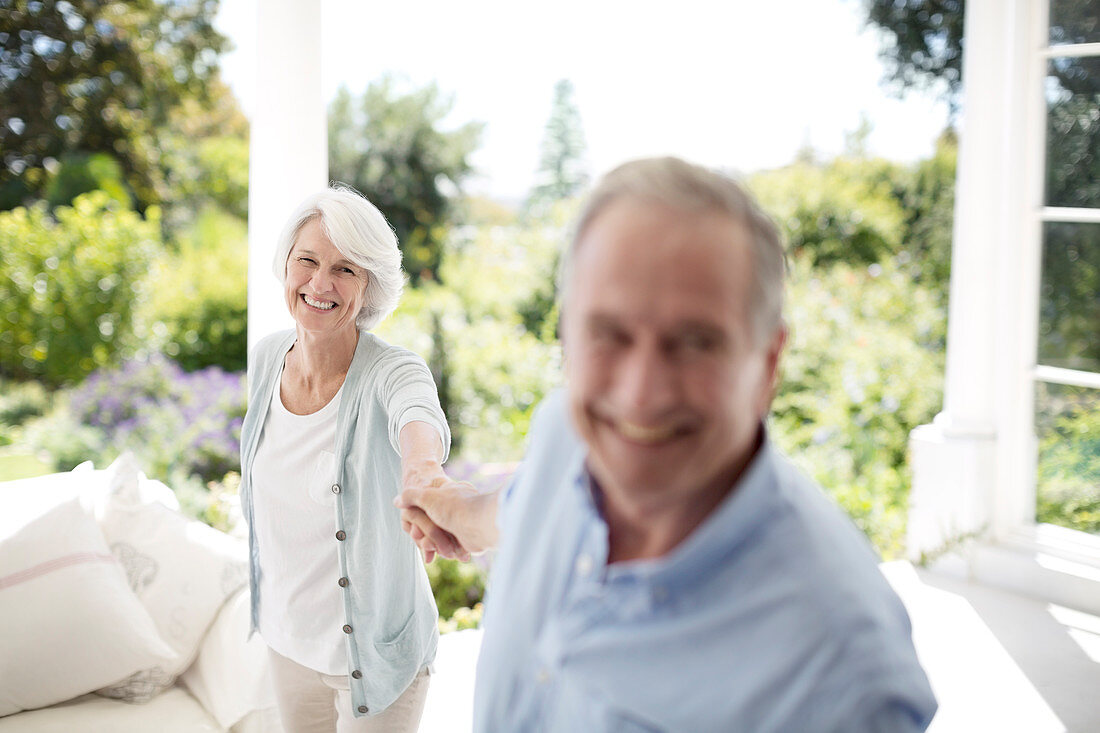 Senior couple holding hands on patio