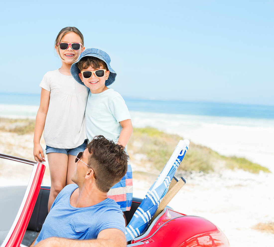 Father and children smiling at beach