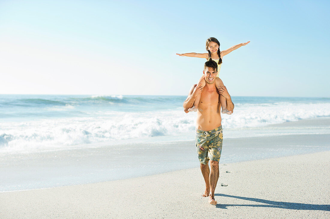 Father carrying daughter on shoulders