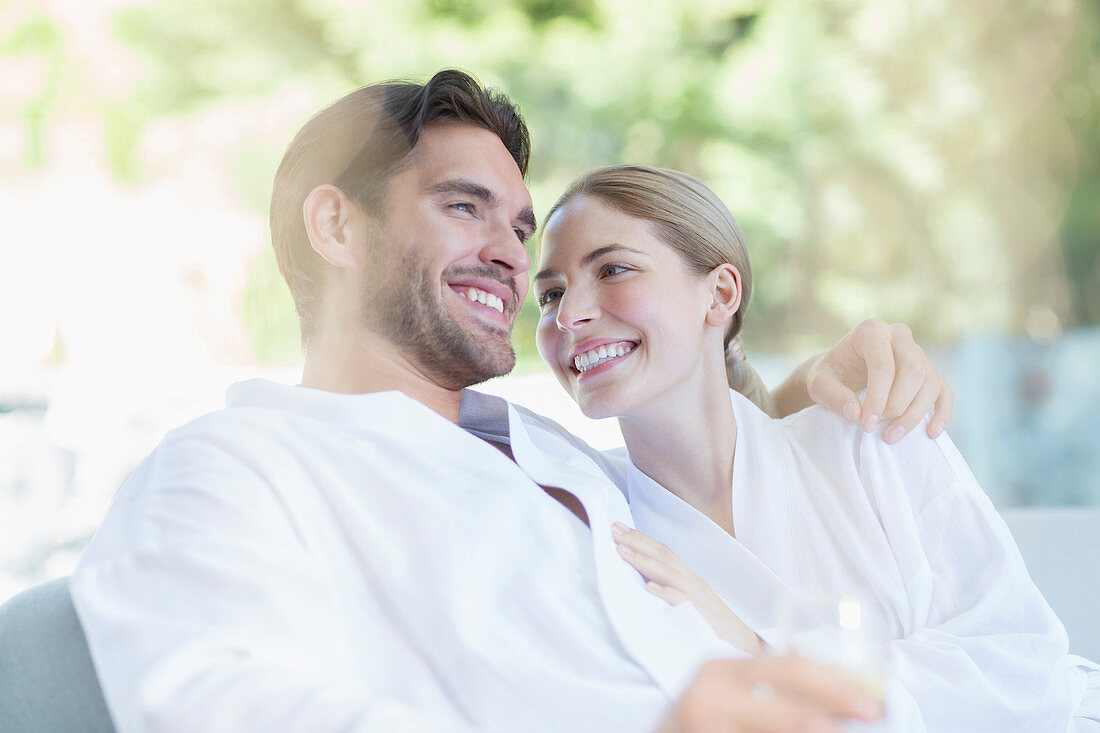 Couple in bathrobes hugging at spa