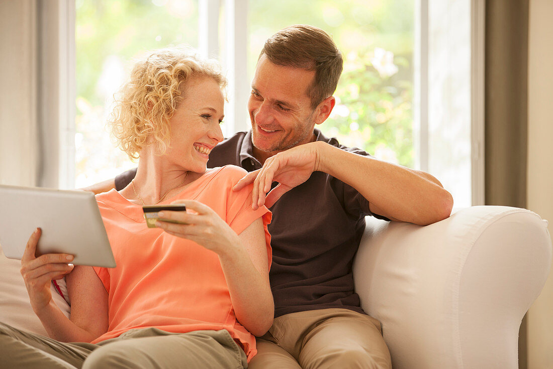 Couple shopping online on sofa