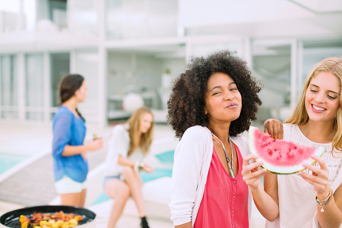 Women eating watermelon at barbecue