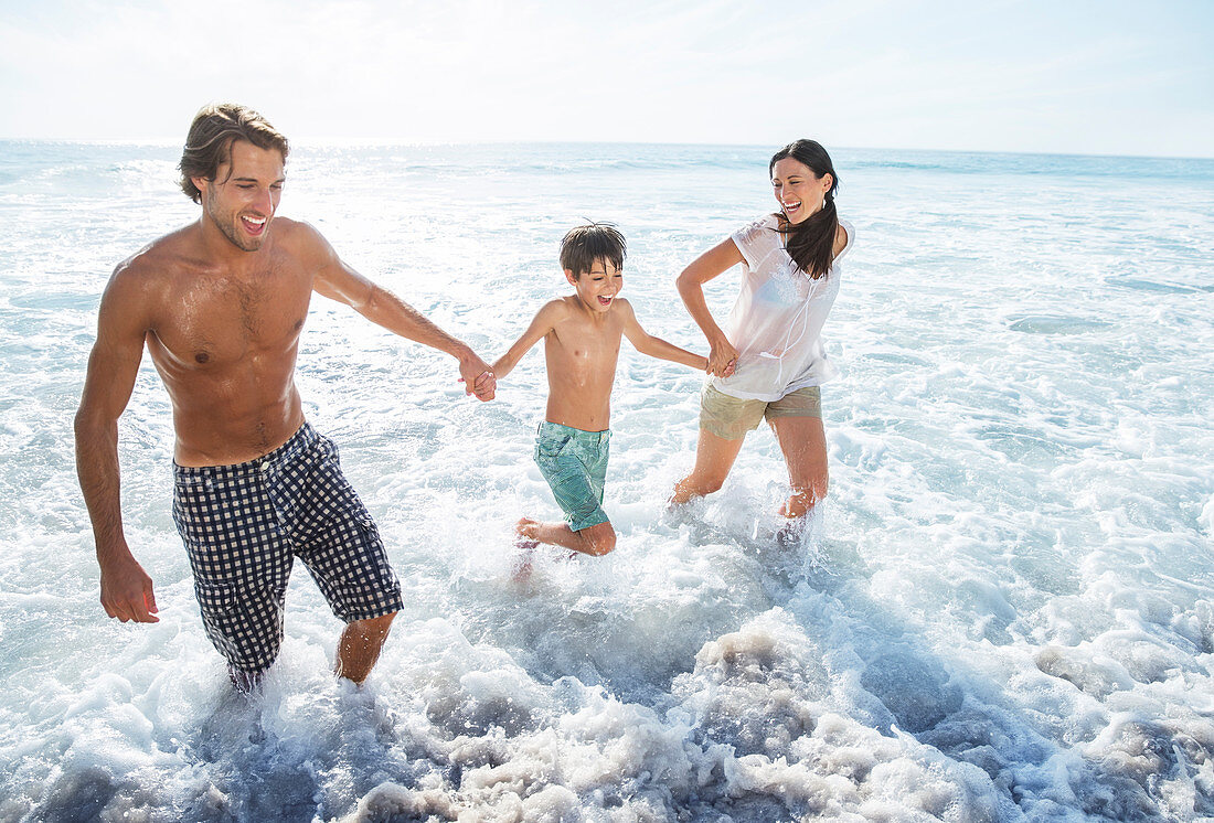 Family playing in waves at beach