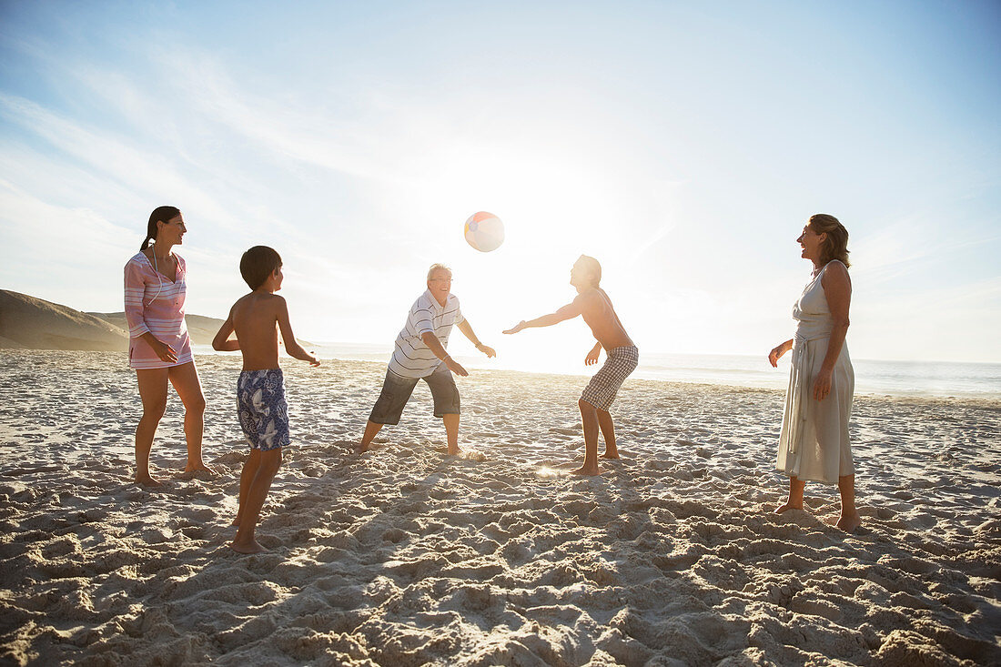 Family playing volleyball on beach