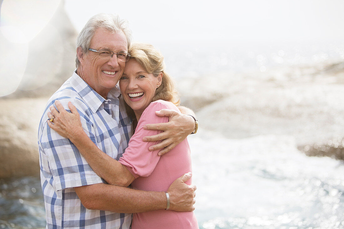 Older couple hugging on beach