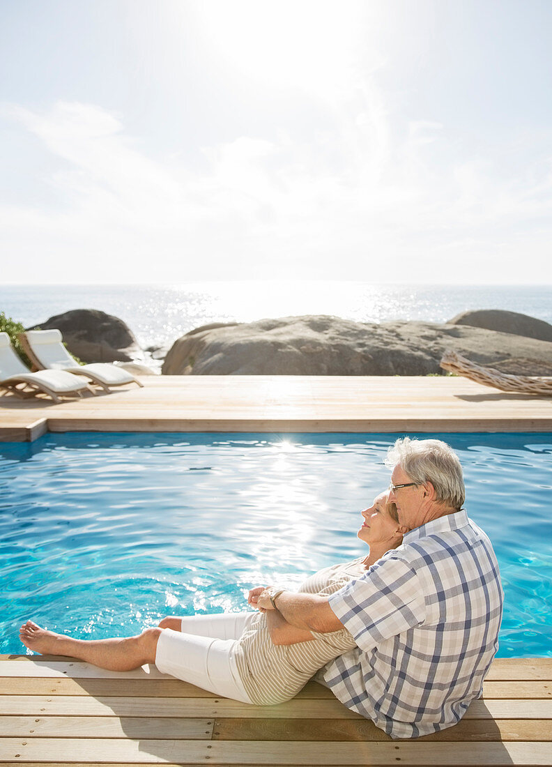 Older couple relaxing by pool