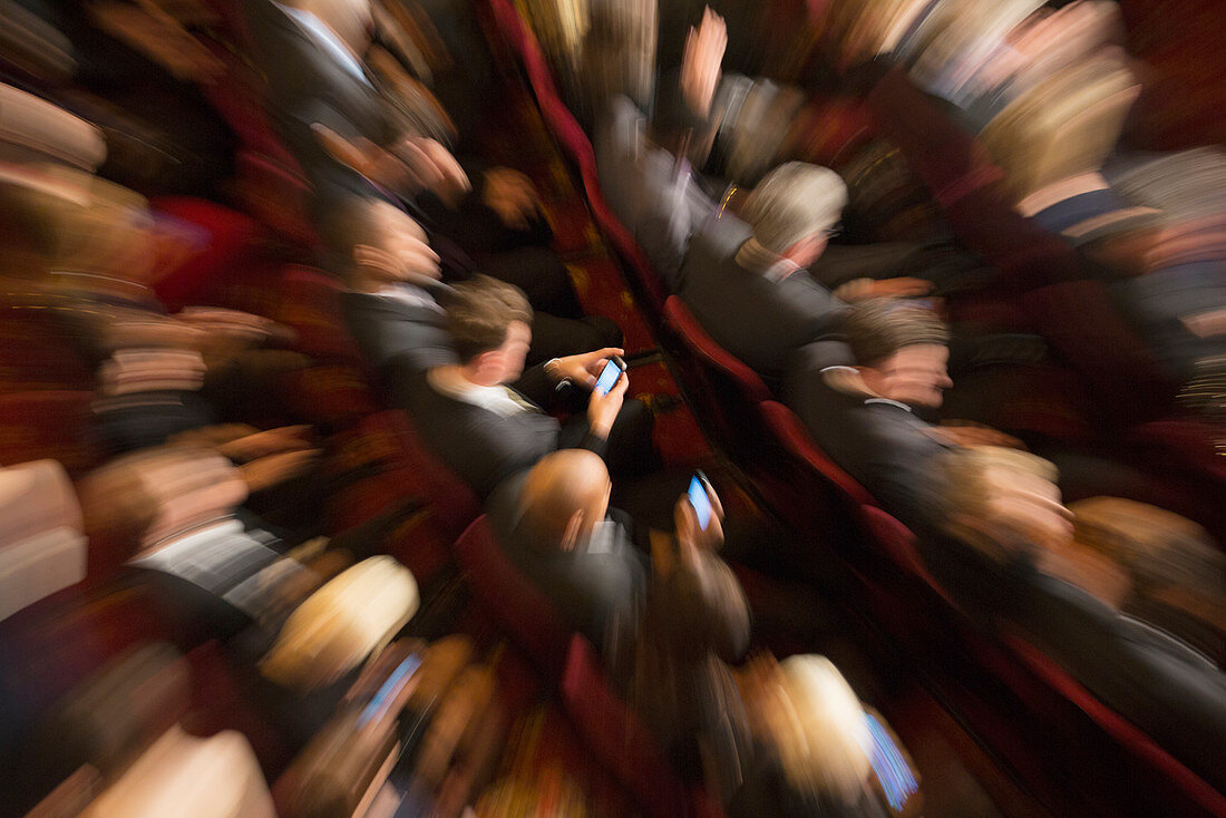 Men using cell phones in theatre audience