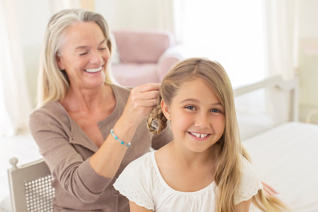 Grandmother braiding granddaughter's hair