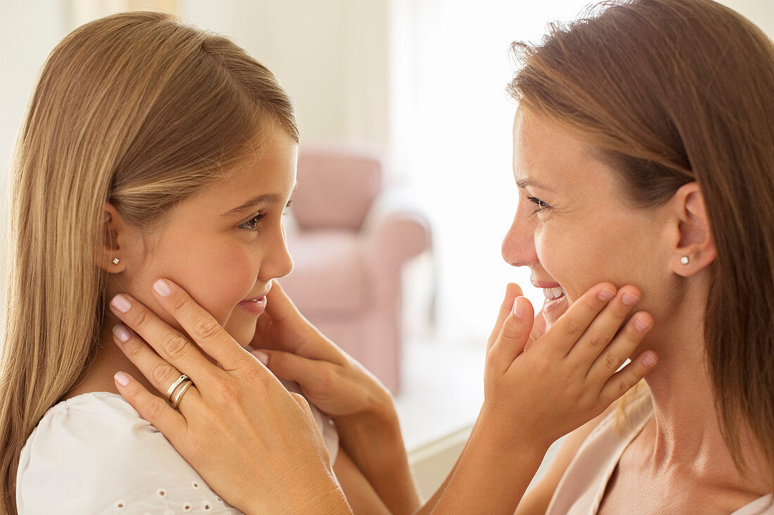 Mother and daughter touching faces