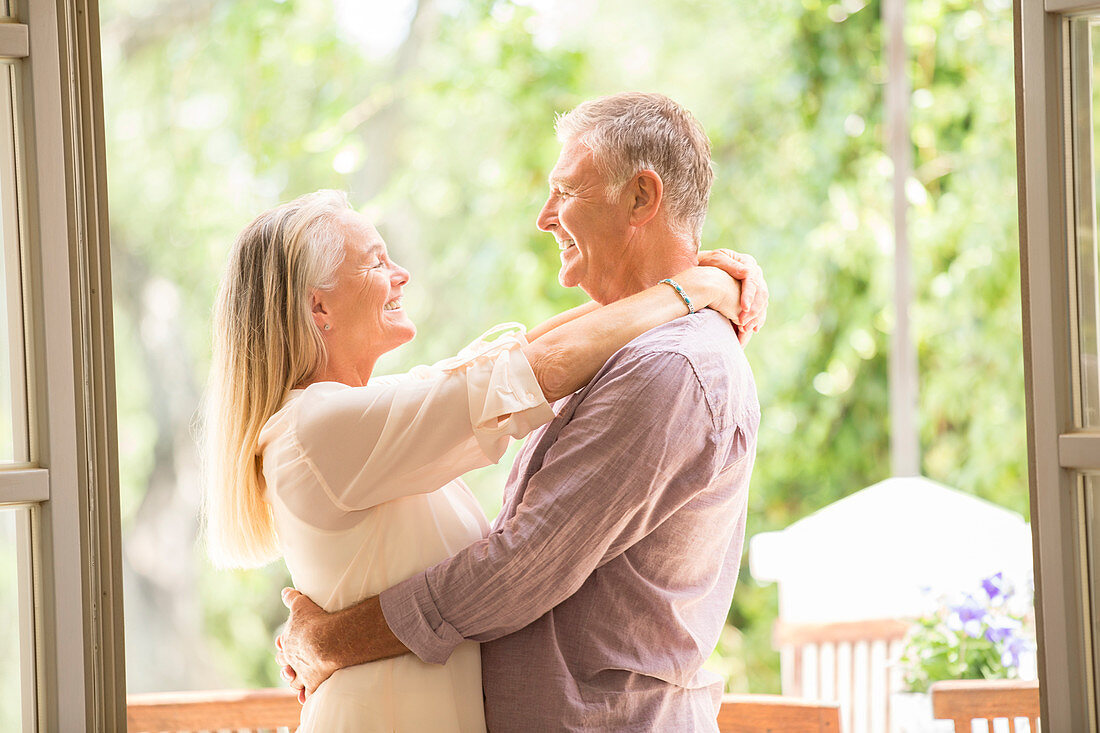 Senior couple hugging in doorway