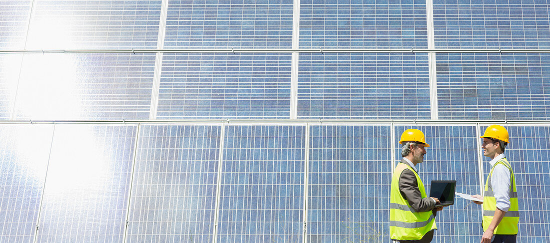 Workers examining solar panels