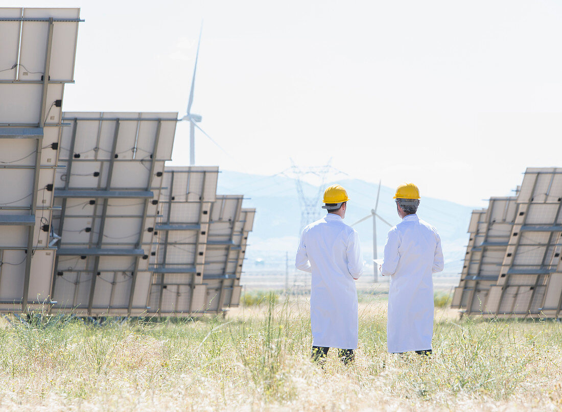Scientists standing by solar panels