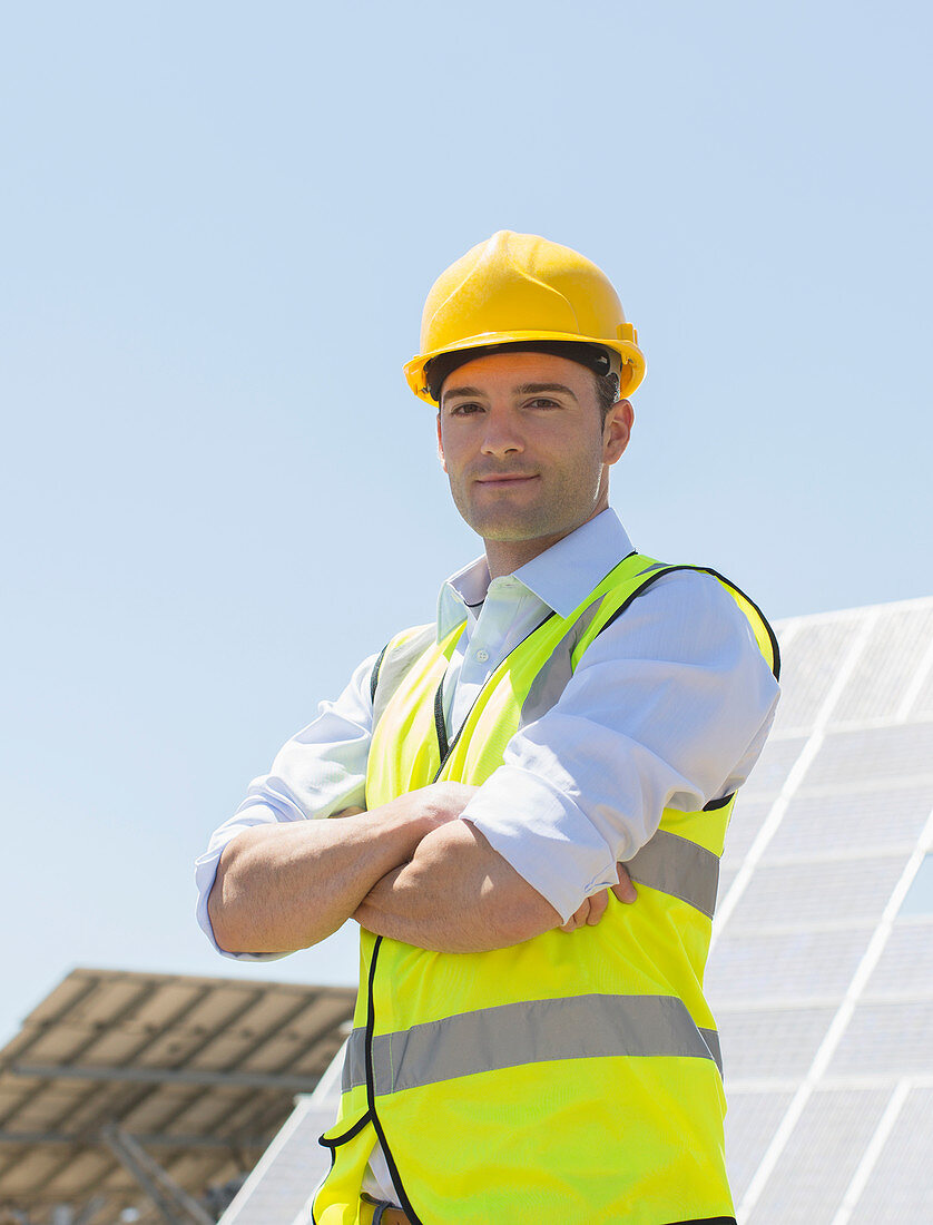 Worker standing by solar panels
