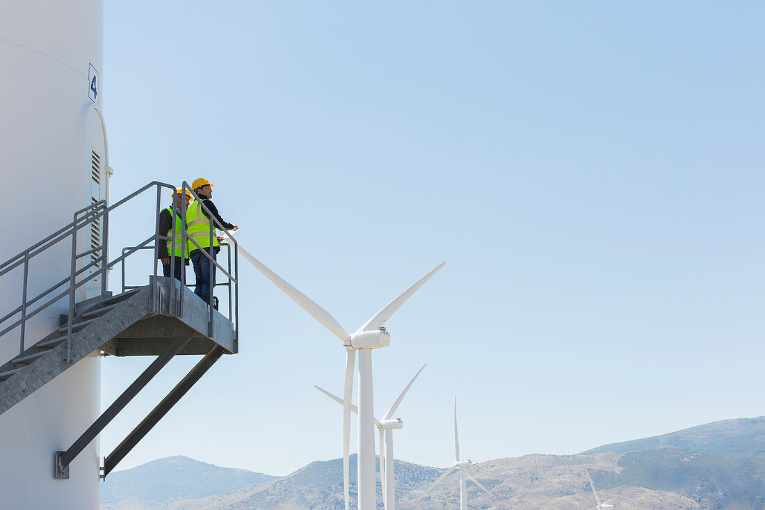 Workers standing on wind turbine