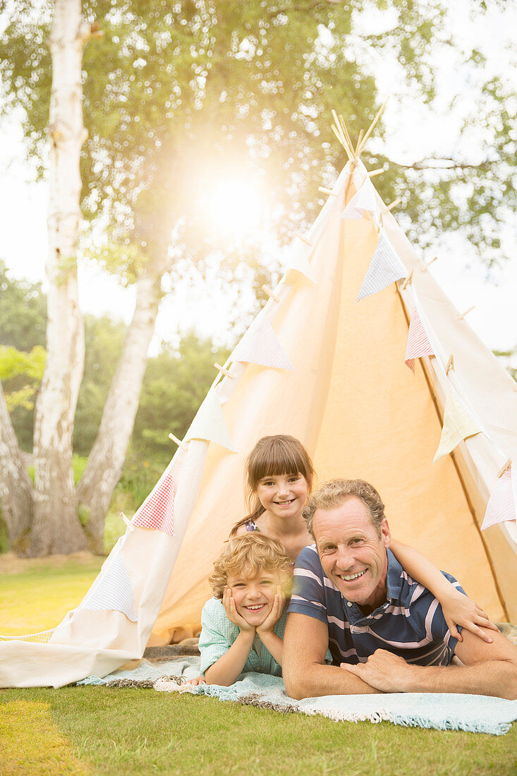 Father and children relaxing in teepee