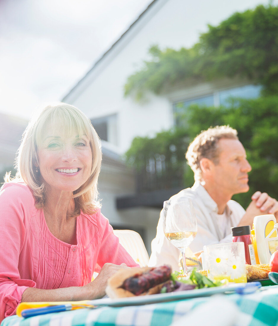 Smiling woman at table in backyard