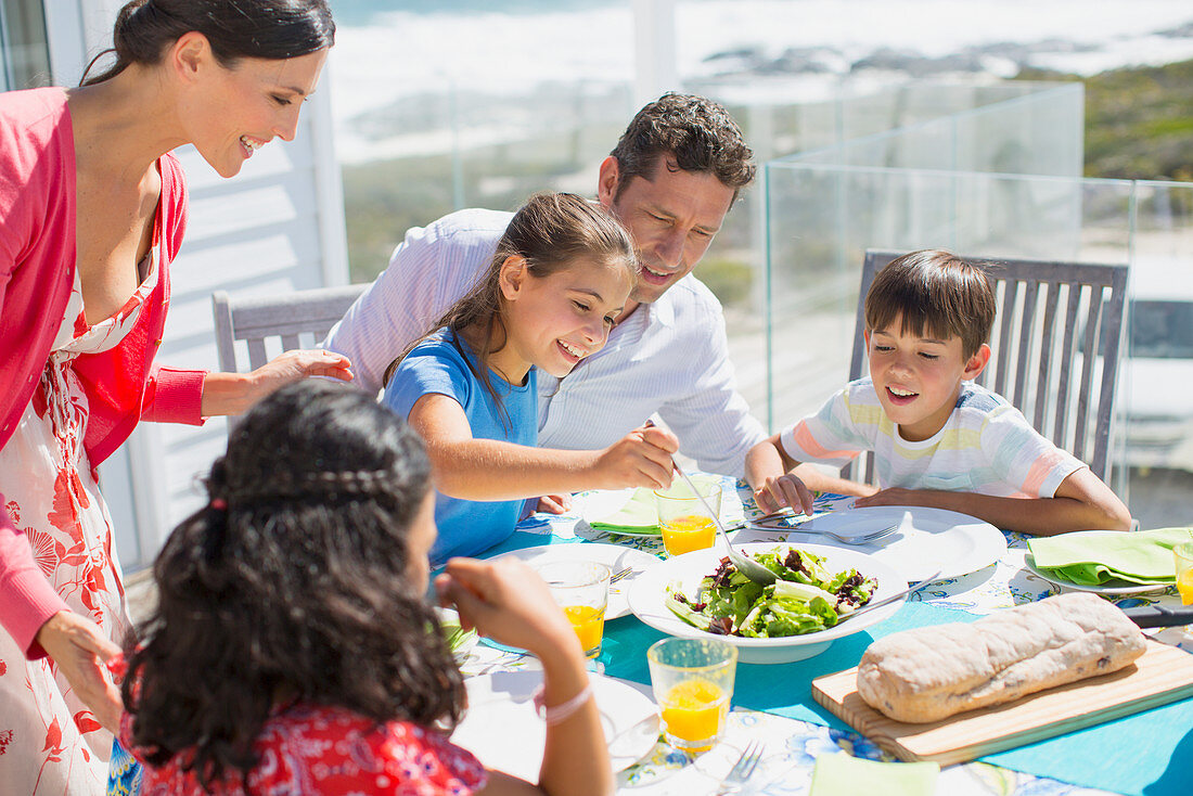 Family eating lunch at table on patio