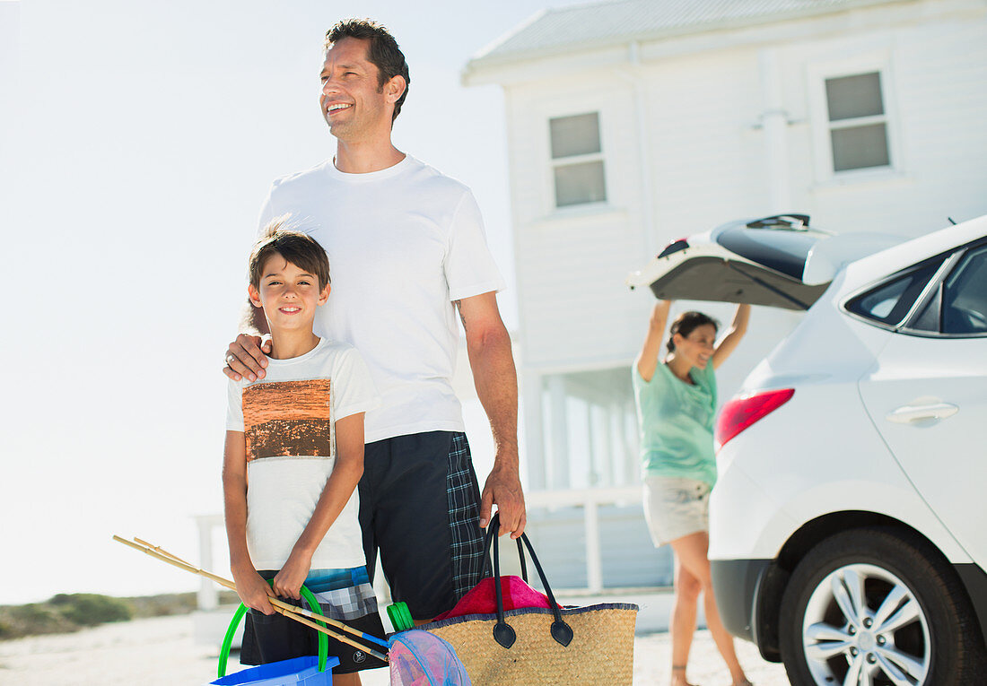 Father and son hugging in sunny driveway