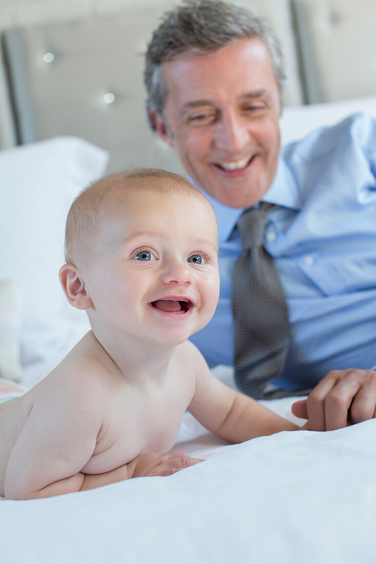 Father and baby relaxing on bed