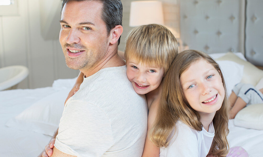 Father and children relaxing on bed