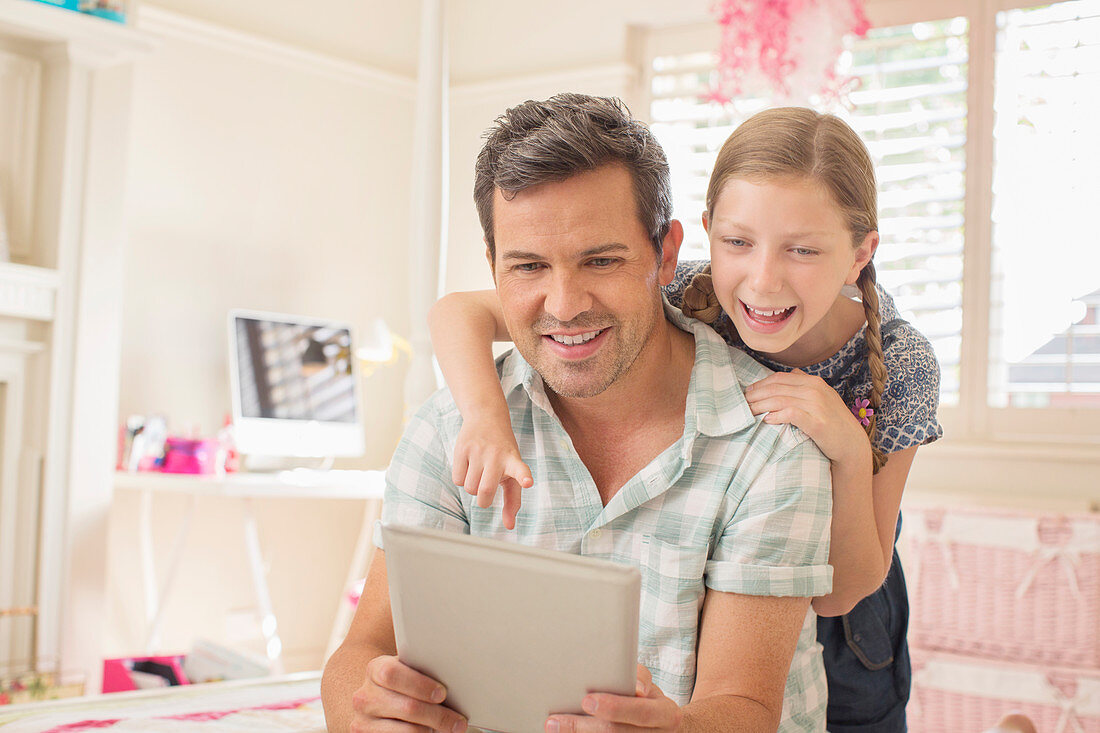 Father and daughter using digital tablet