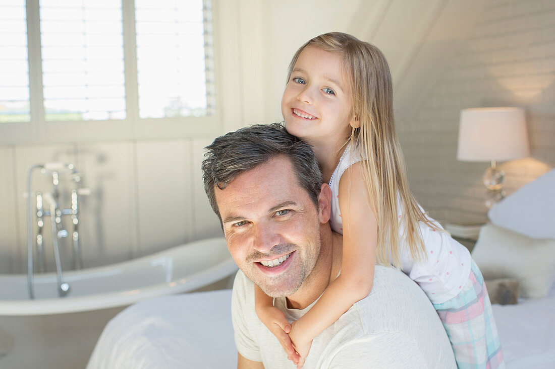 Father and daughter smiling in bedroom