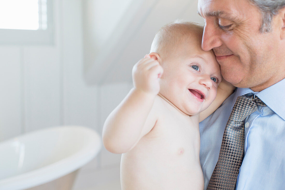 Father holding baby in bathroom