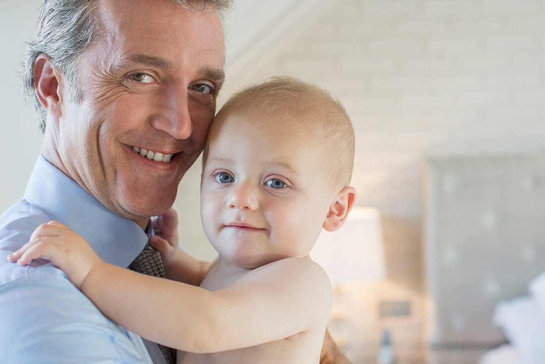 Father holding baby in bedroom