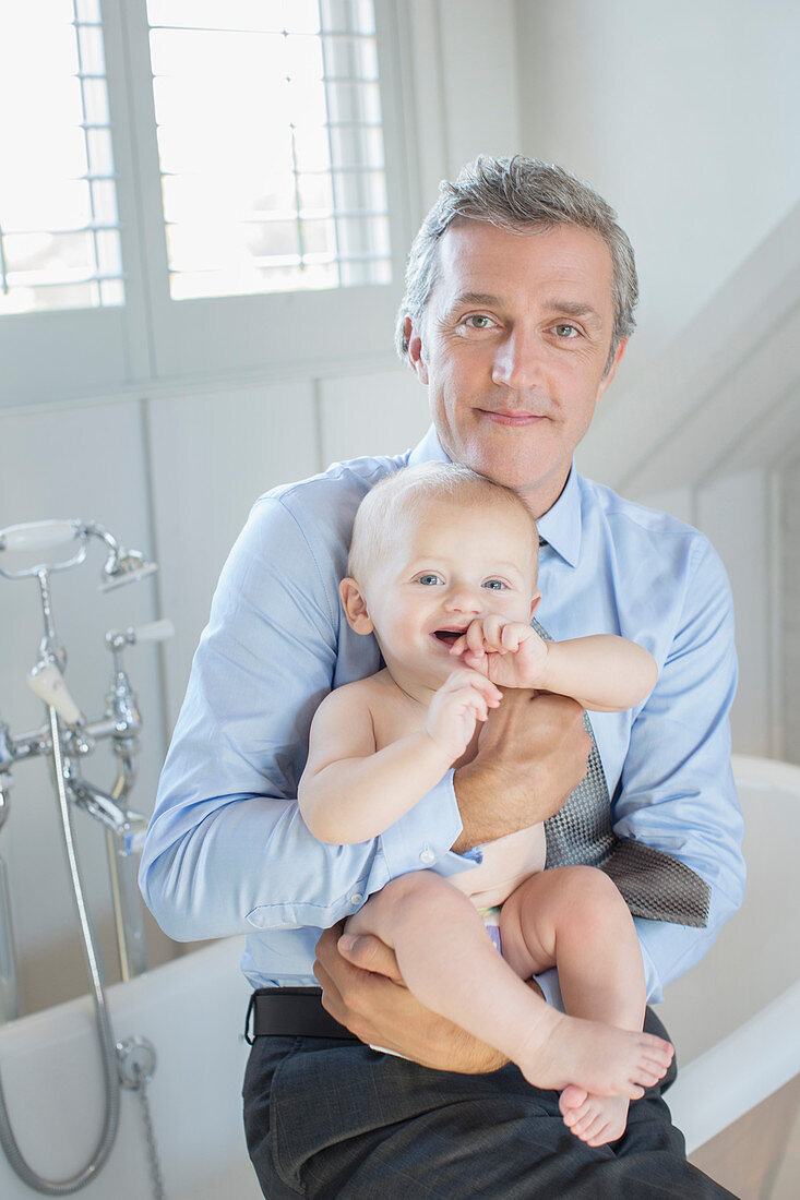 Father holding baby in bathroom