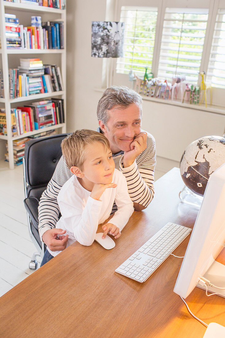 Father and son using computer together