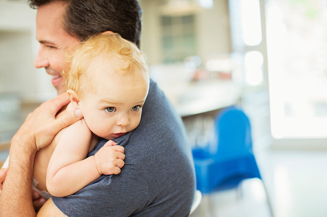 Father holding baby in kitchen