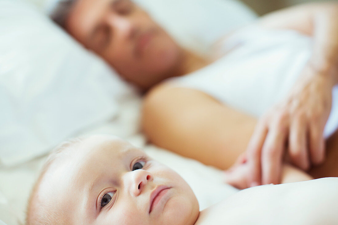 Father and baby laying on bed