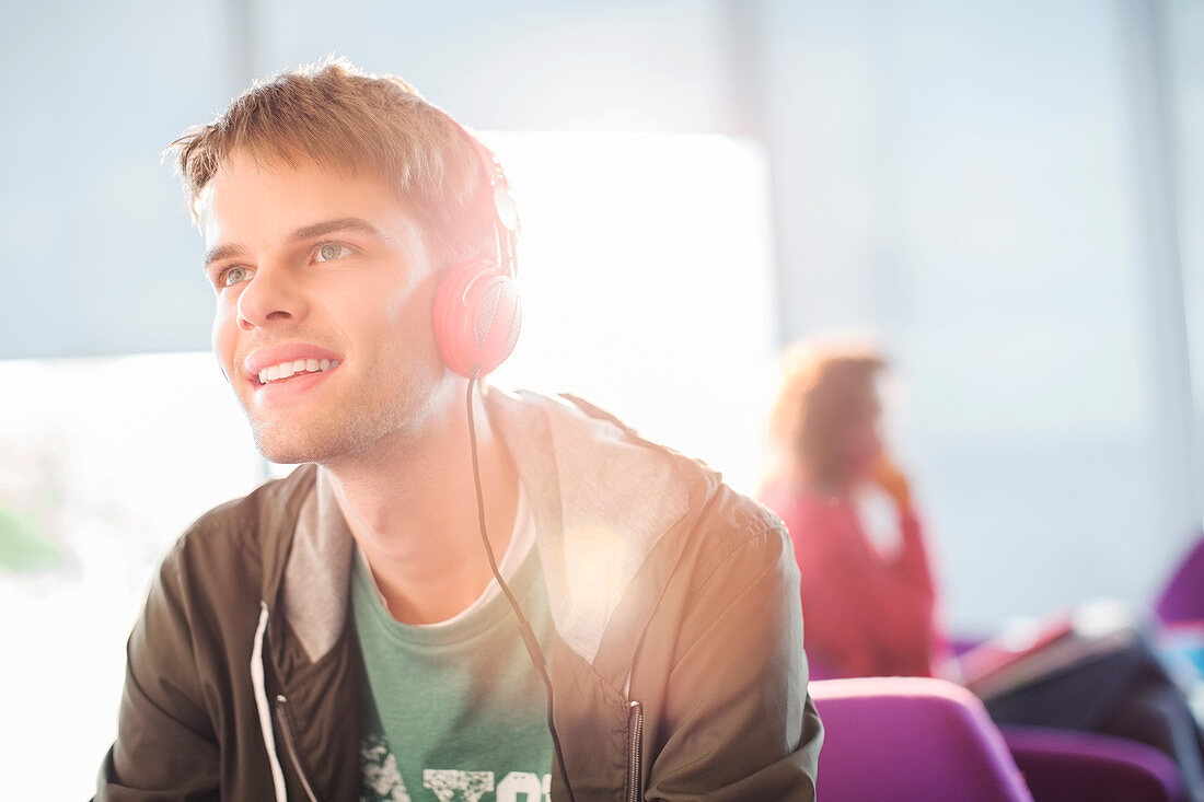 Young man listening to headphones indoors