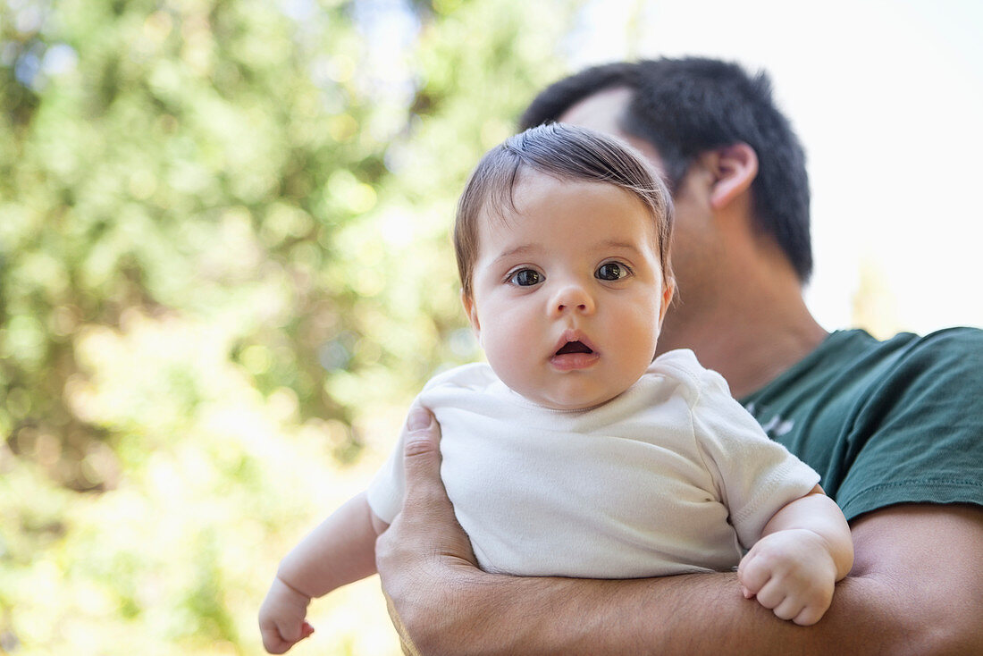 Father carrying baby girl outdoors