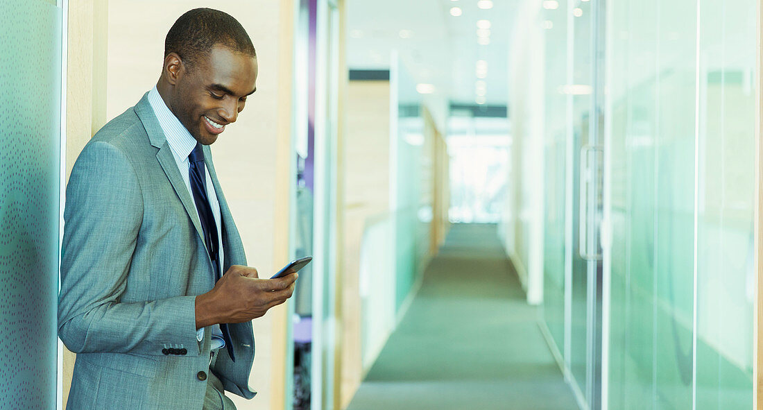 Businessman using cell phone in office