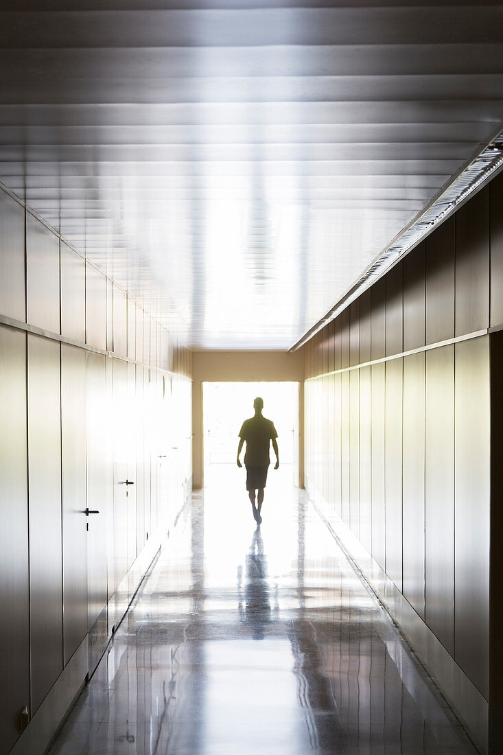 Silhouette of person walking in corridor