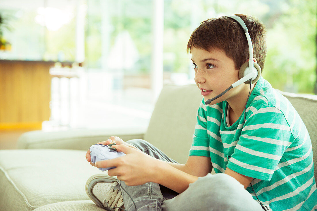 Boy playing video games on sofa