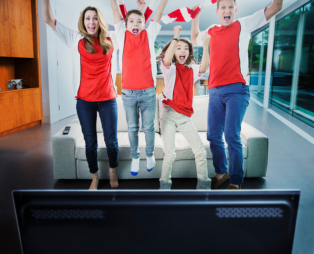 Family cheering in front of television