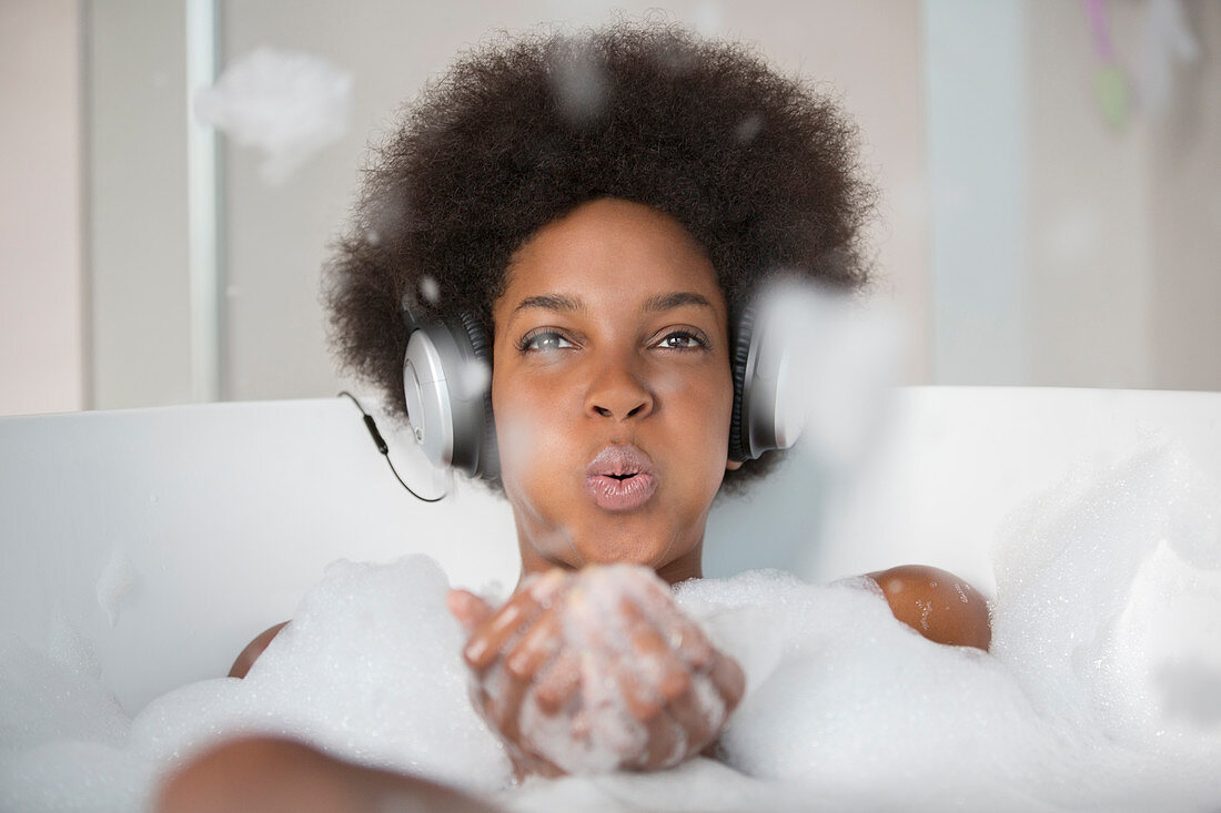 Woman listening to headphones in bath