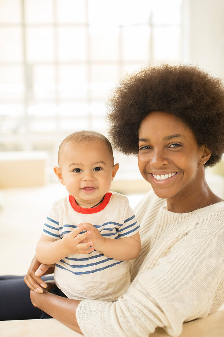 Mother holding baby boy on sofa